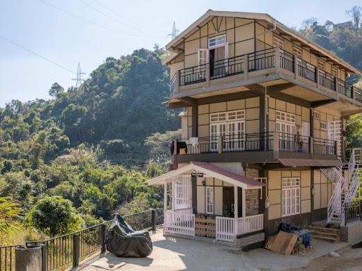 a large building with a balcony on a mountain at Teecee in Āīzawl