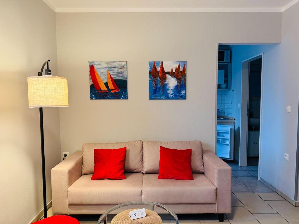 a living room with a couch with red pillows at Apartment Pangani Teichhof Fehmarn in Wenkendorf