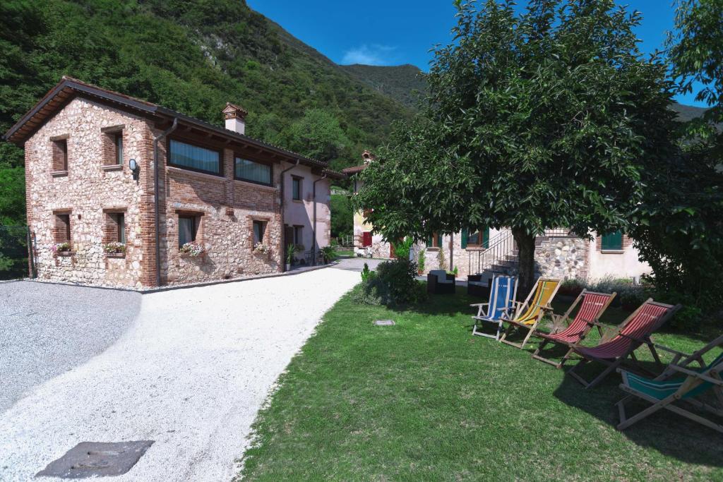 grupa krzeseł siedzących przed budynkiem w obiekcie B&B Mulino di Campese w mieście Campese