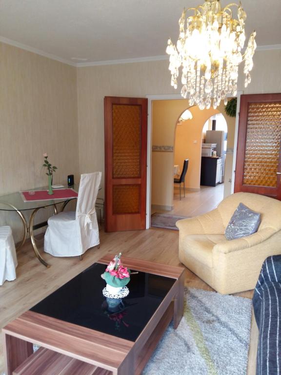 a living room with a coffee table and a chandelier at City Centre Apartment in Győr