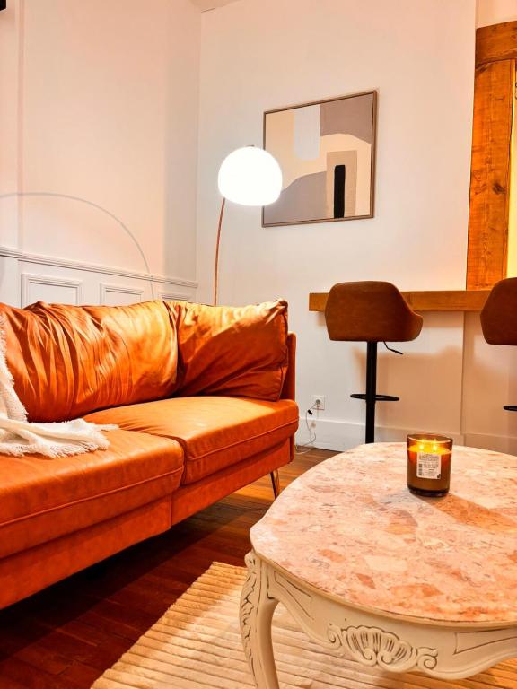 a living room with a couch and a table at Le Clair-Obscur in Paray-le-Monial
