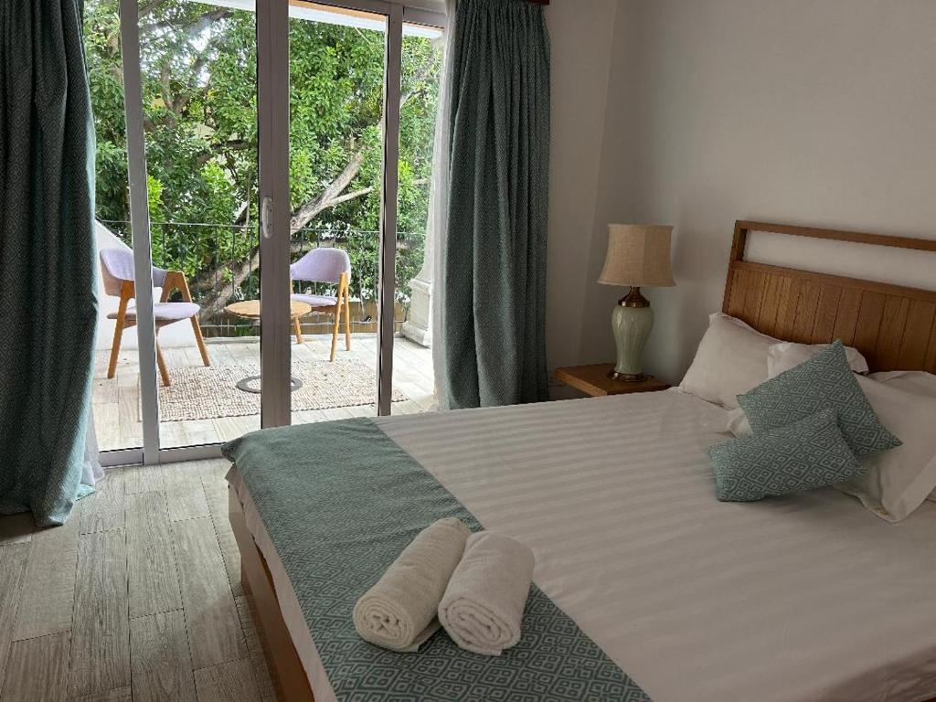 a bedroom with a bed with two towels on it at Lakaz feuillaze in Port Mathurin