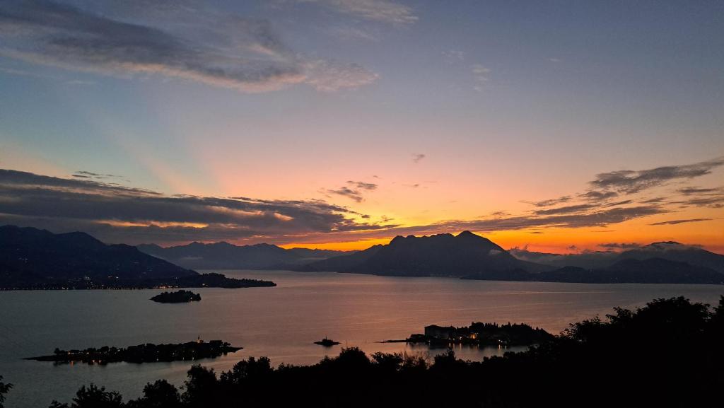 a sunset over a body of water with mountains at Shambala Home Loft Sole in Someraro