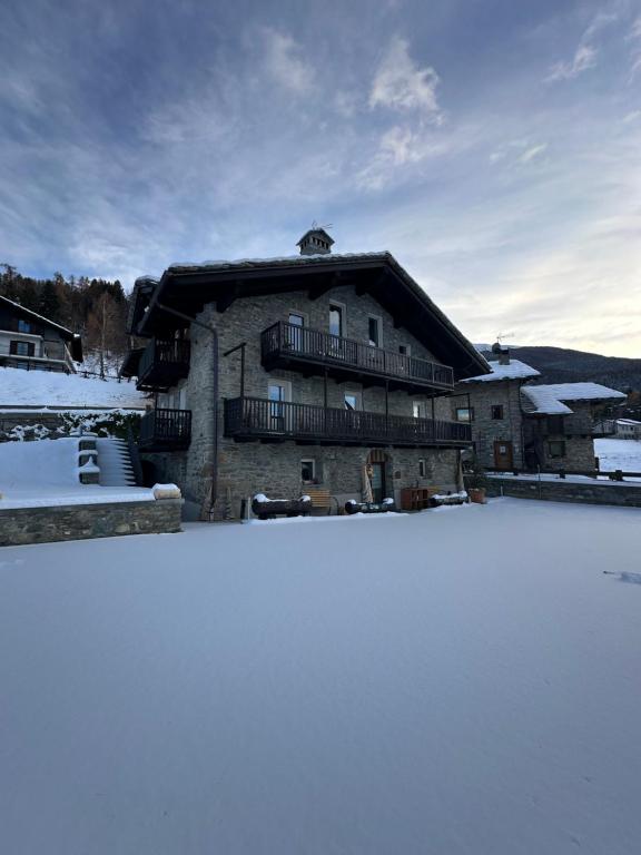 ein großes Gebäude mit Schnee davor in der Unterkunft Nellali in Gressan