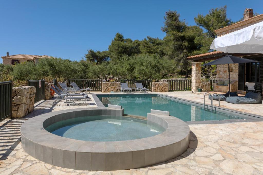 a large swimming pool with a patio and a swimming poolvisor at Villa Lida Aresti by Sealand Villas in Agios Leon