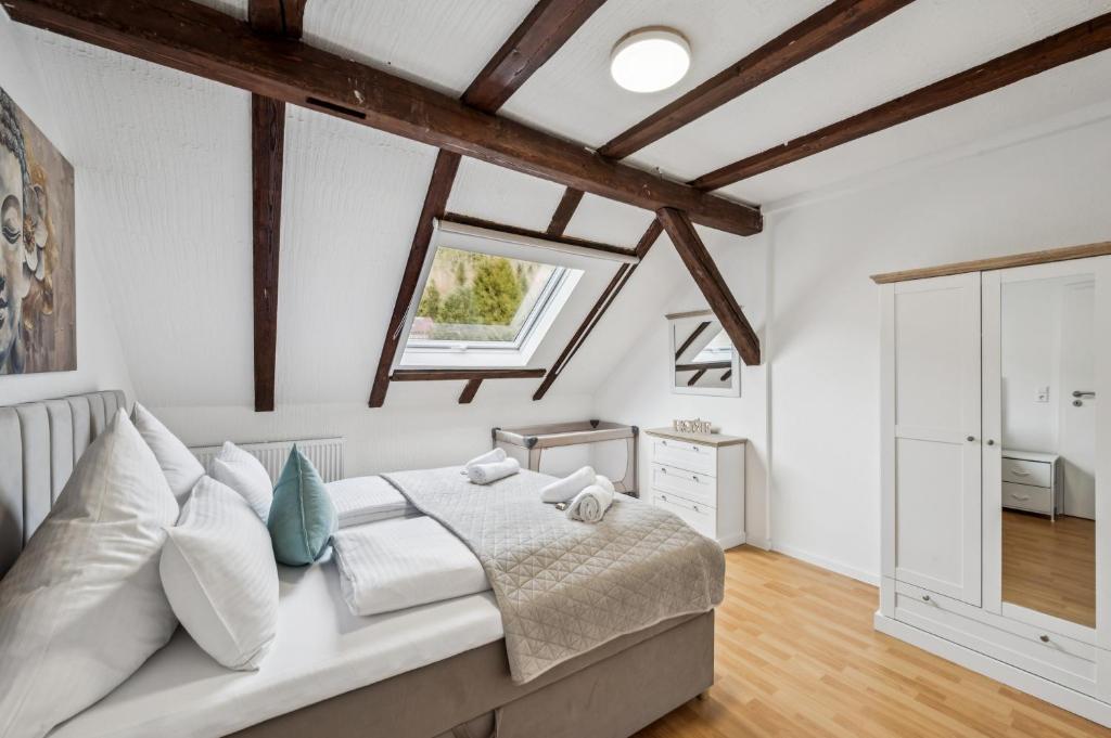 a bedroom with white walls and wooden beams at Ramoni Apartments - Bad Wildbad in Bad Wildbad