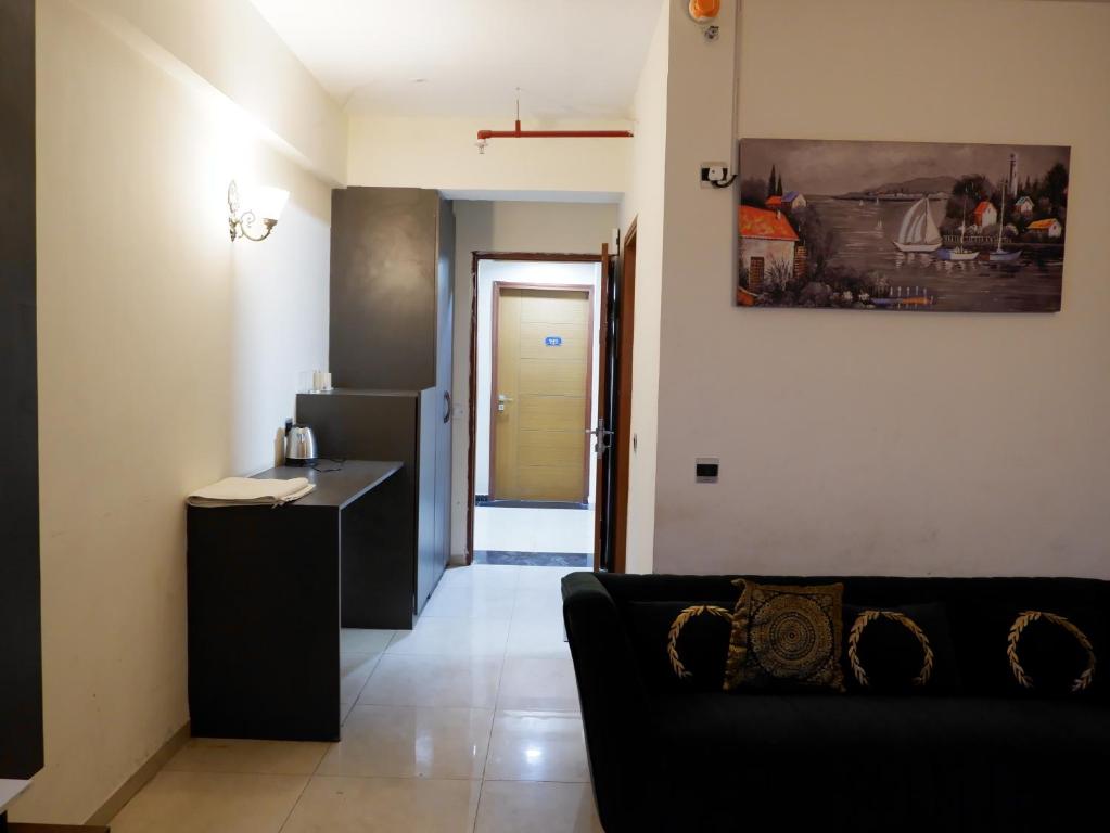 a living room with a couch and a kitchen at lucknowi stay in Lucknow