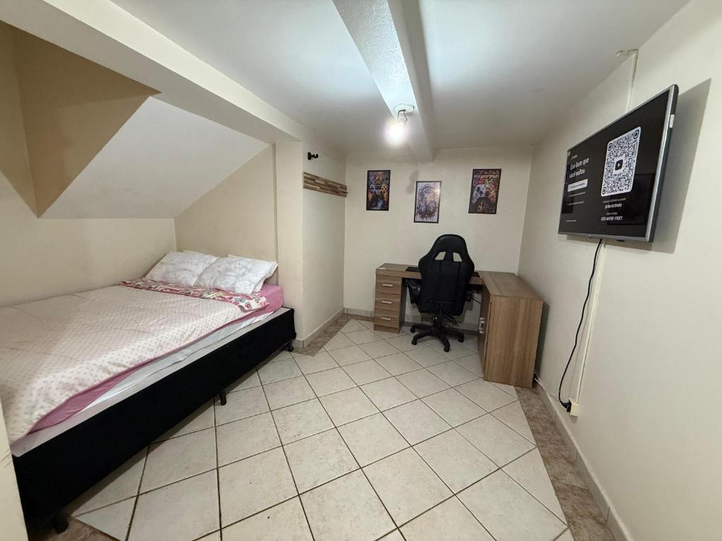 a bedroom with a bed and a desk and a chair at Quarto em ótima localização in Botucatu