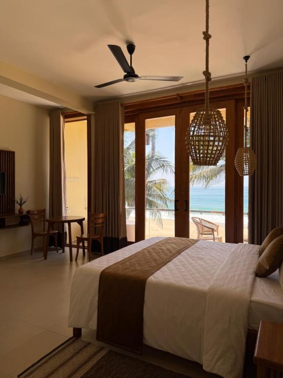 a bedroom with a bed and a view of the ocean at Piña Boutique Hotel - Beachfront in Habaraduwa Central