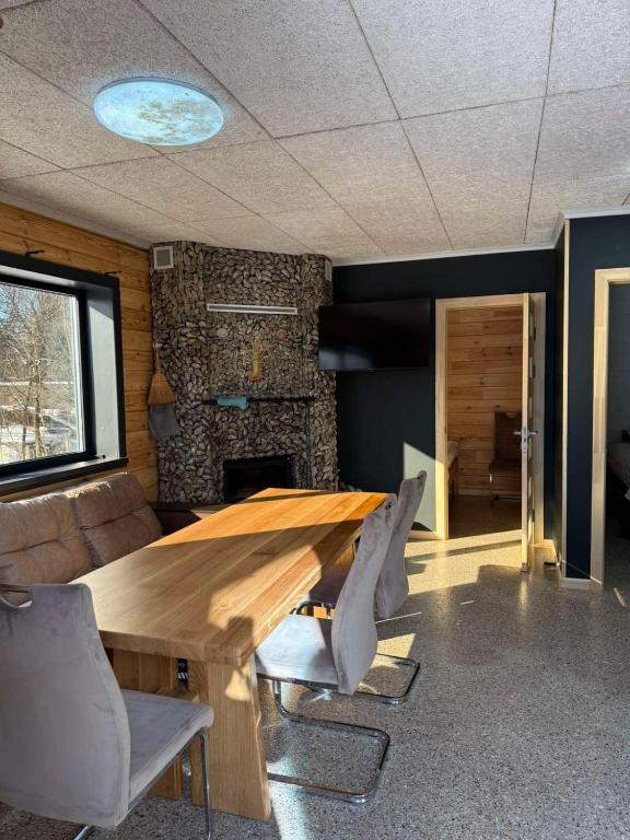 a dining room with a wooden table and chairs at Kolyba Club in Stanishovka