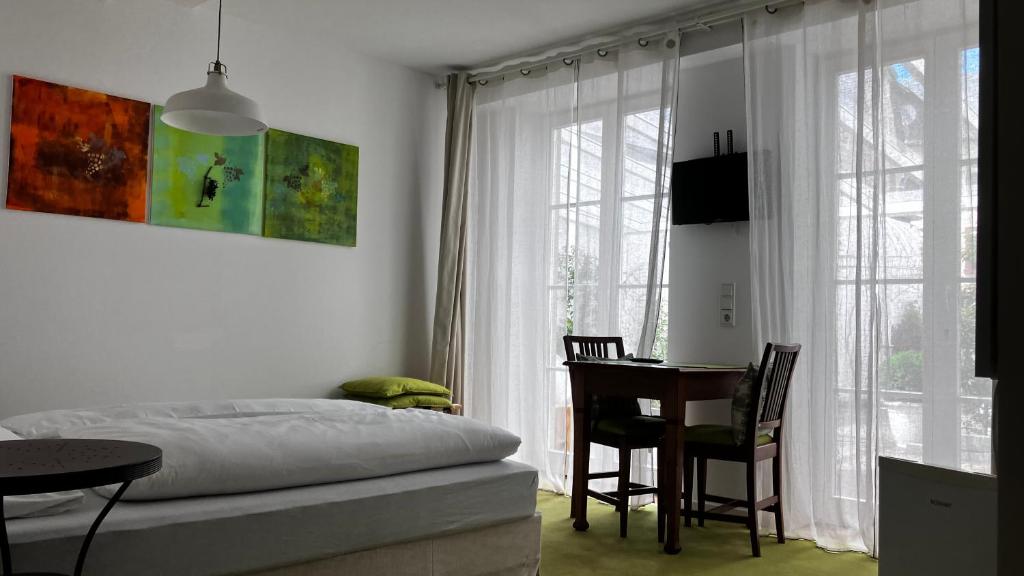 a bedroom with a bed and a table and a desk at Wanderer und Radlerzimmer in Lieser