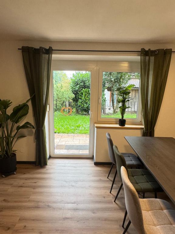 a dining room with a table and a large window at Moderne große Wohnung mit Garten in Hausham