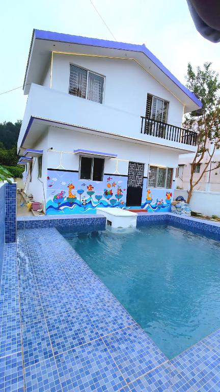 a house with a swimming pool in front of a house at 3BHK - Bamboo Private Pool Villa Yercaud in Yercaud