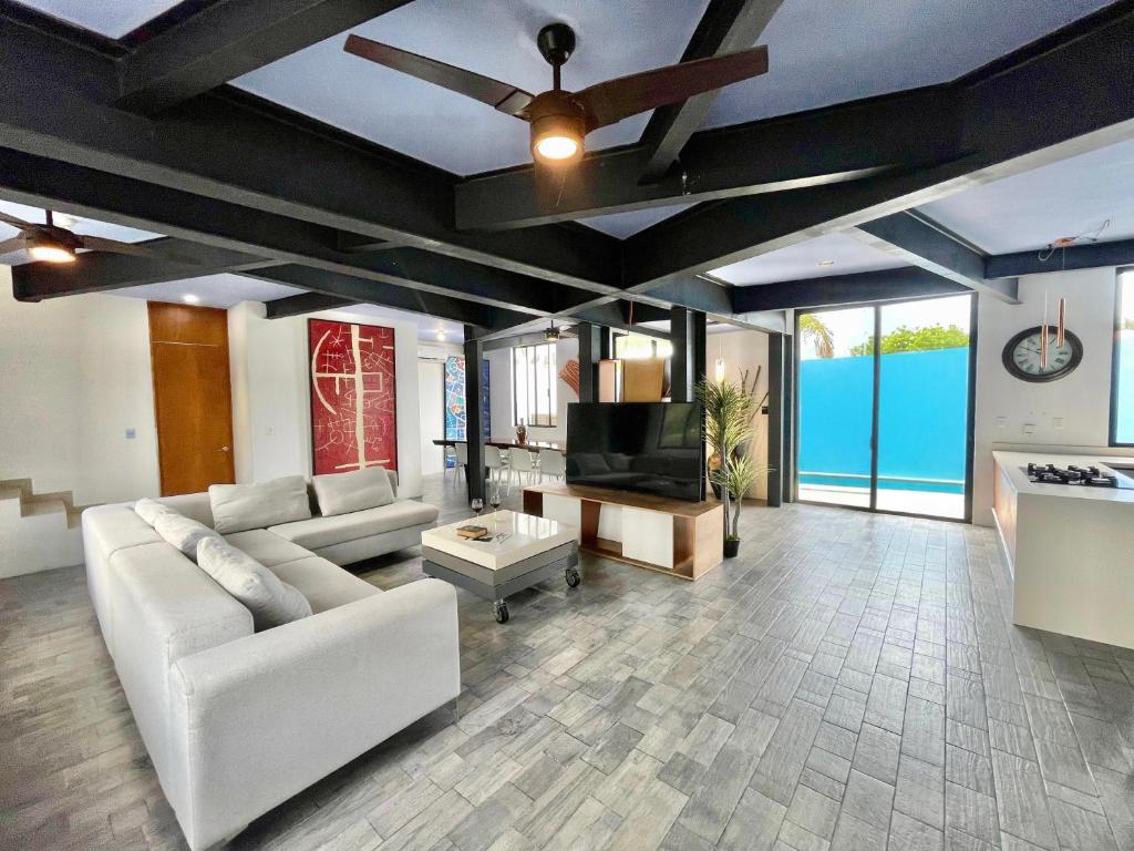 a living room with a couch and a ceiling fan at Casa Gigante de lujo, con piscina privada, 4 amplias habitaciones con baño privado in Playa del Carmen