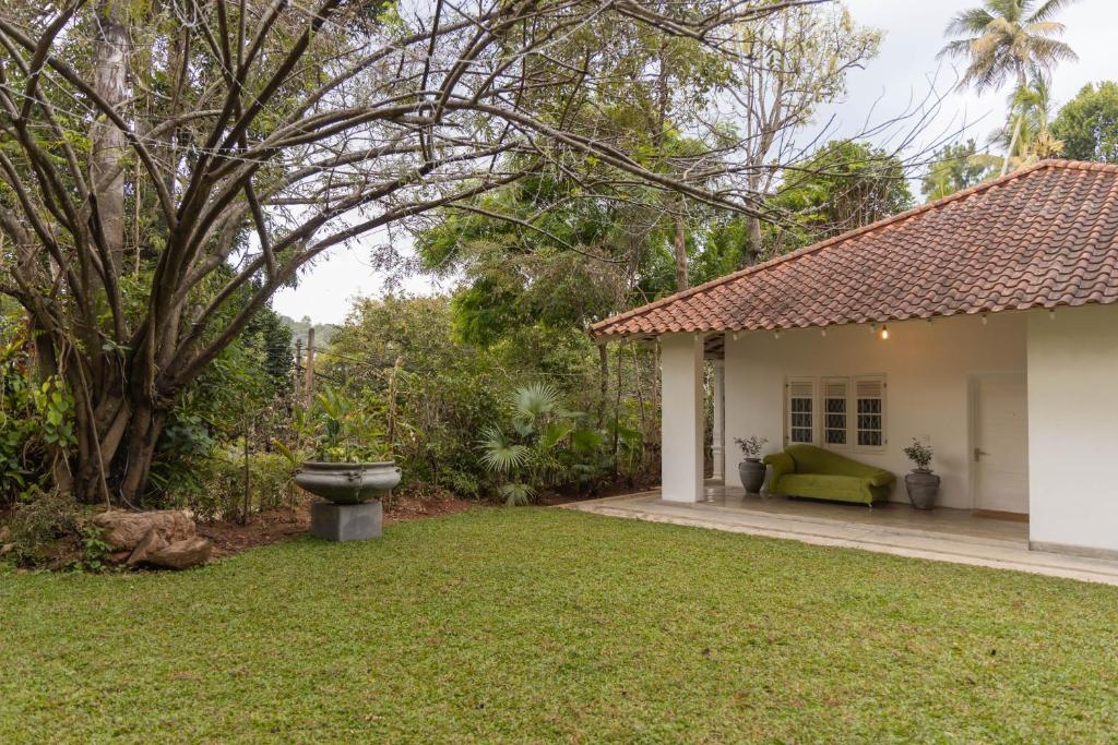 a backyard of a house with a green lawn at Heuvel Villa Kandy in Kandy