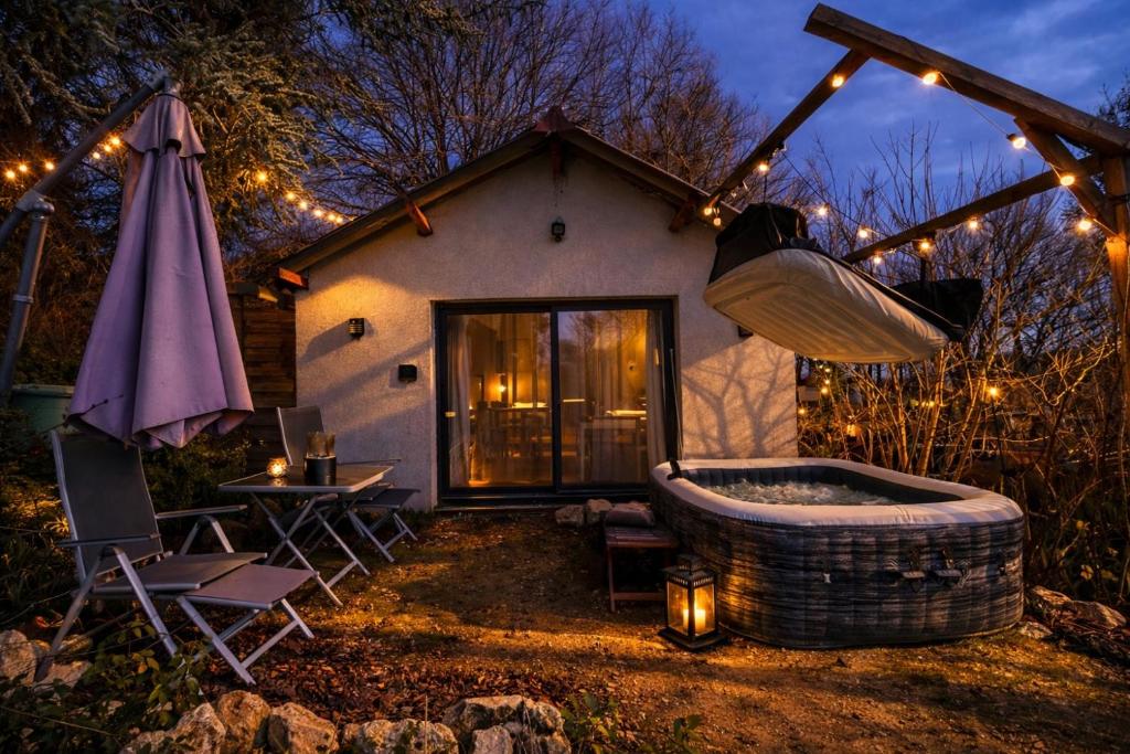 a hot tub in front of a house with lights at Cottage cosy avec spa privatif - escapade romantique Val de Loire in Chouzy-sur-Cisse