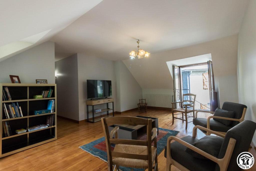 a living room with a couch and chairs and a tv at Calme et montagne in Cazaux-Layrisse