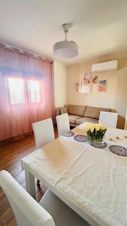 a living room with a table and white chairs at Apartamento La Hera in Belvis de Monroy