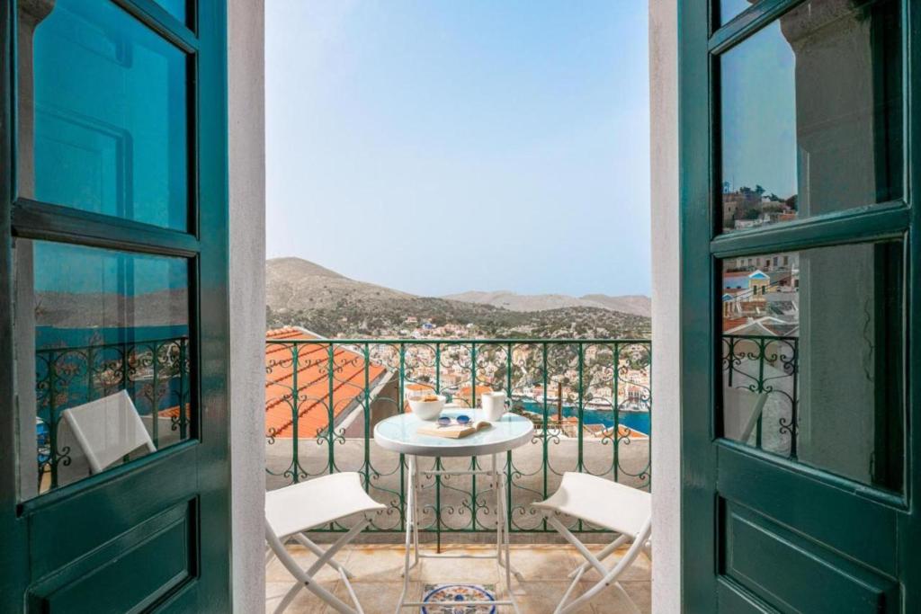 a view from a balcony with a table and chairs at Aerino in Symi
