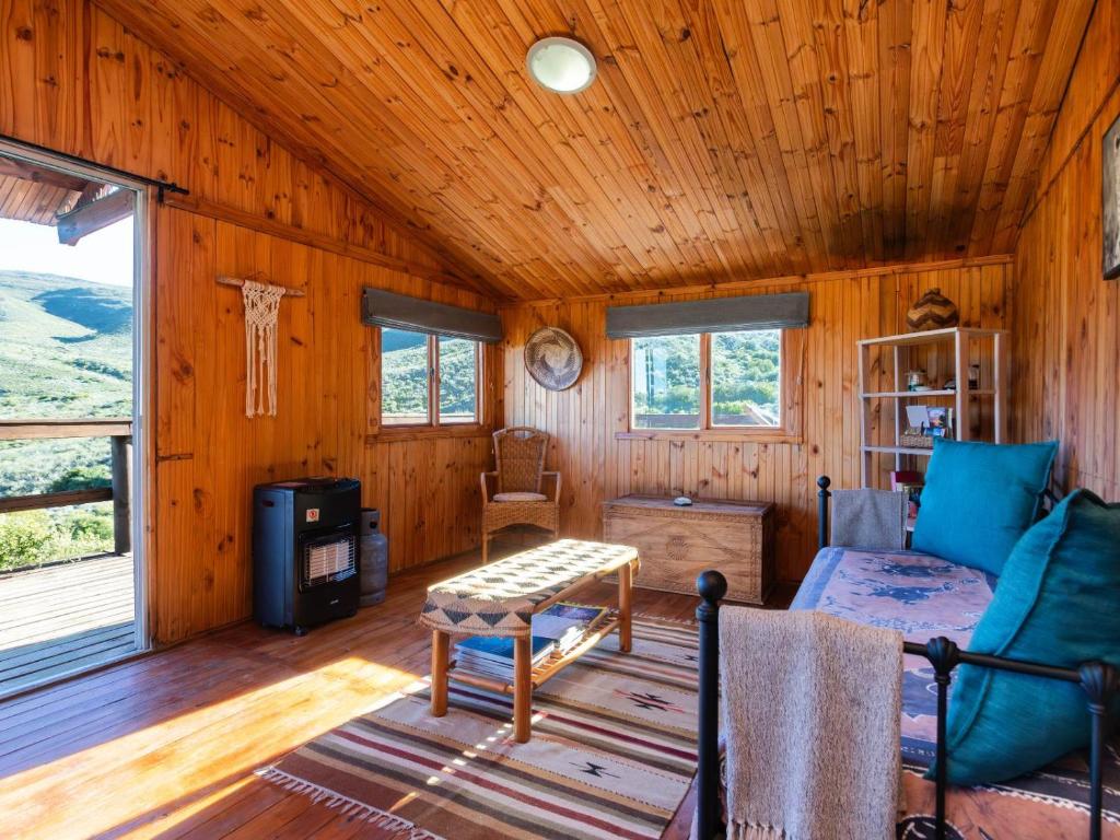 a living room of a cabin with wooden walls at Bloukrans Off-Grid Cabin in Montagu