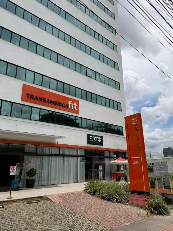a tall building with a sign in front of it at Transamerica Fit Contagem in Contagem