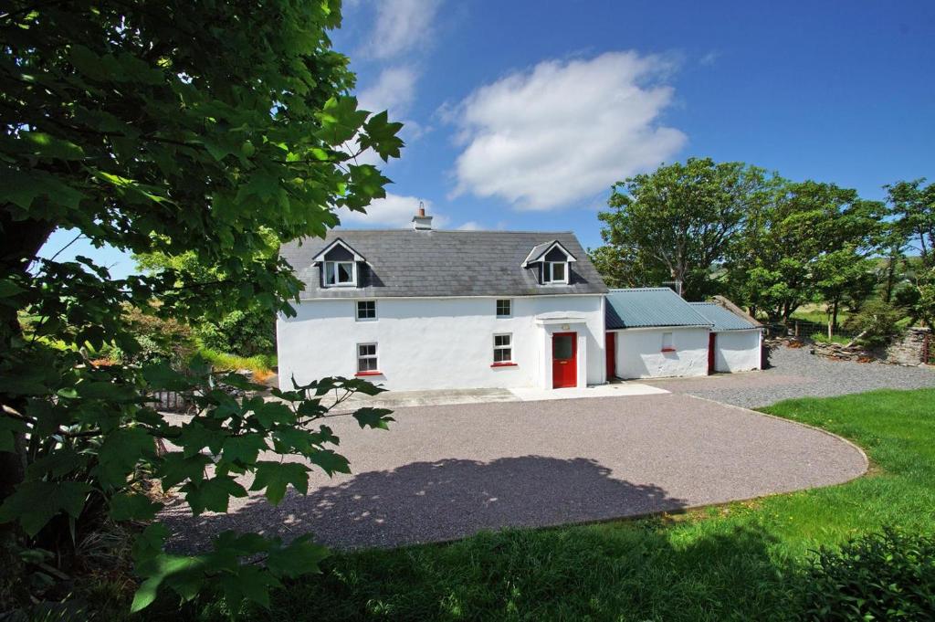 a white house with a red door and a driveway at 3 Bed in Cahirciveen oc-i417 in Reenard Cross