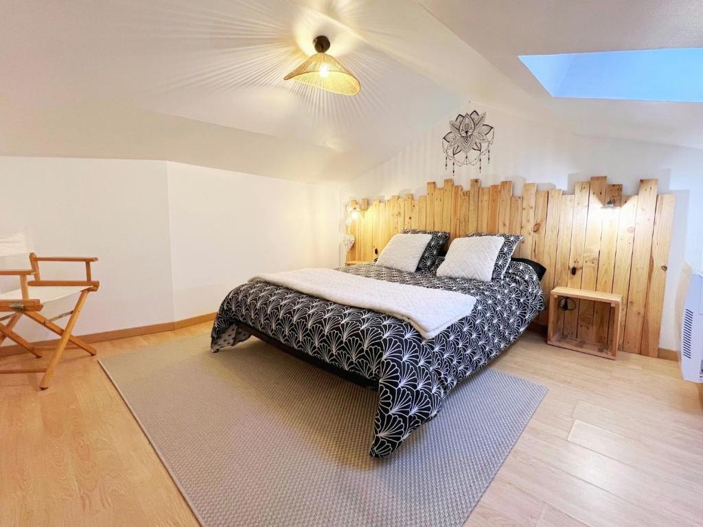 a bedroom with a bed with a wooden wall at La Maison Bonheur - Authentique et Centrale in Cerizay