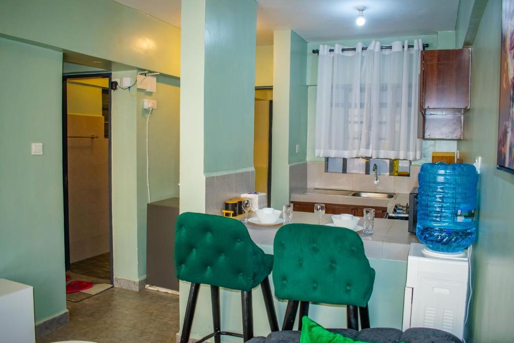 a kitchen with two green chairs and a sink at Norlan Homes Kisumu in Kisumu