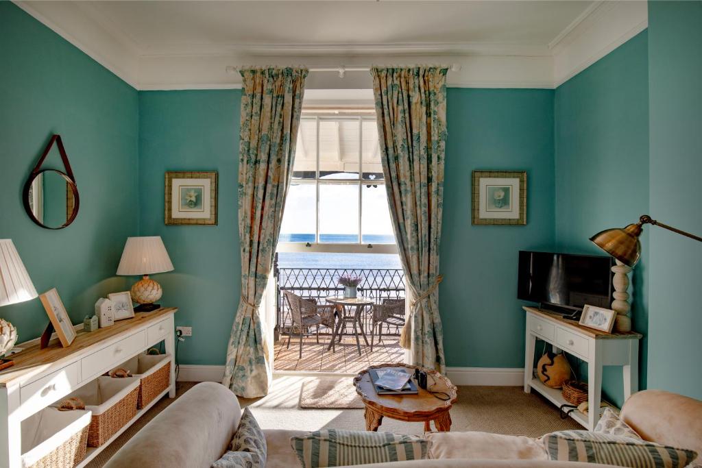 a living room with blue walls at Mariners Balcony Apartment in Sidmouth