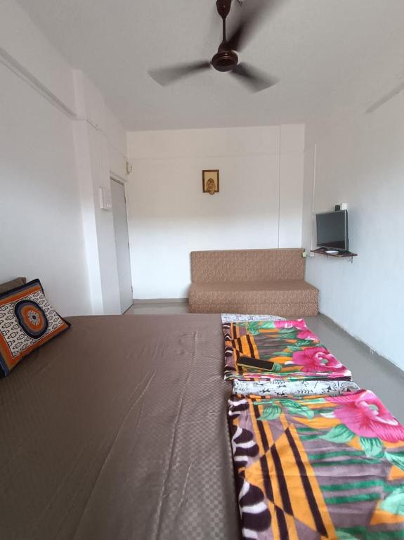 a room with a bed and a couch in it at Dapolihideaway in Dapoli