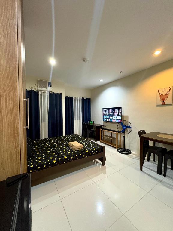 a room with a bed and a tv in it at The Midpoint Residences - Studio Unit in Cebu City