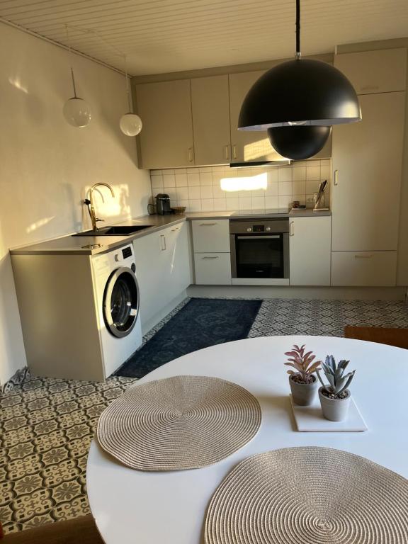 a kitchen with a washing machine and a table at Charming townhouse in CityCenter Townhouse - free parking in Odense