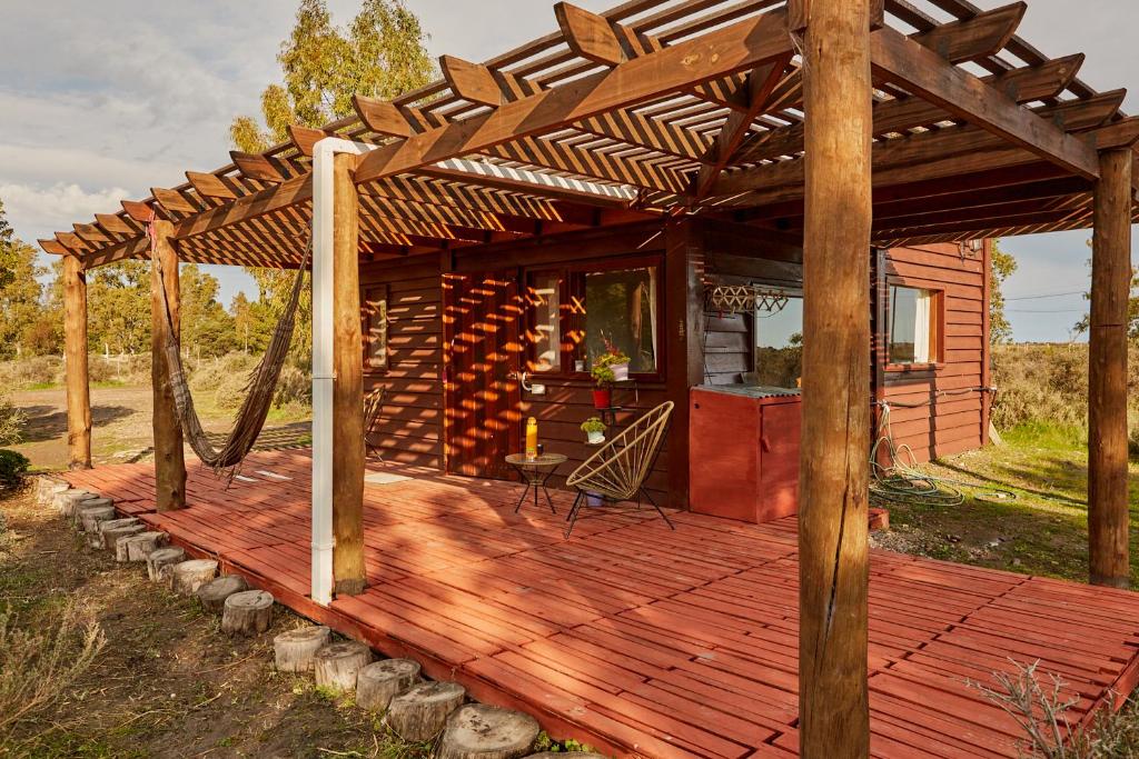 a wooden deck with a wooden pergola at Cabaña Viedma in Viedma