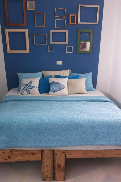 a bedroom with a large bed with blue walls at Casa Carlotta - 100m from the Beach, Maio in Vila do Porto