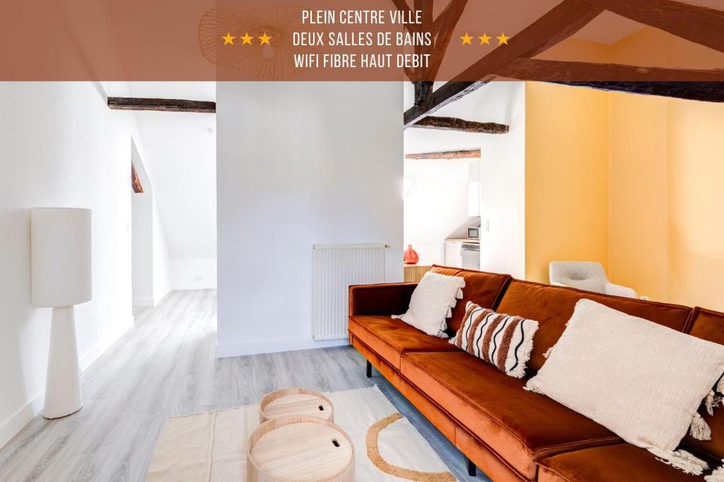 a living room with a brown couch and orange walls at Plein centre, 2 chambres, lumineux, "Traverse" in Sarlat-la-Canéda