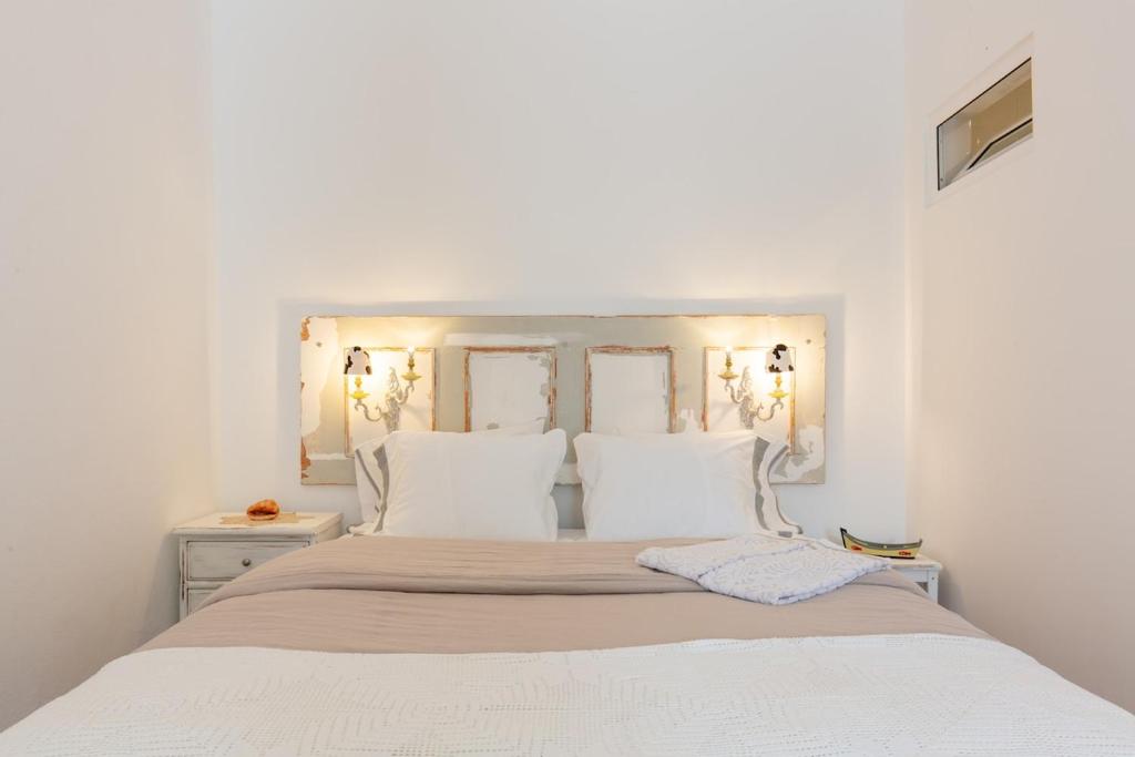 a white bedroom with a white bed with white pillows at Garden view in Cascais