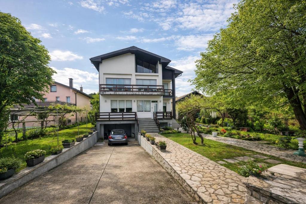 a house with a car parked in the driveway at Apartment Una Laguna in Bihać