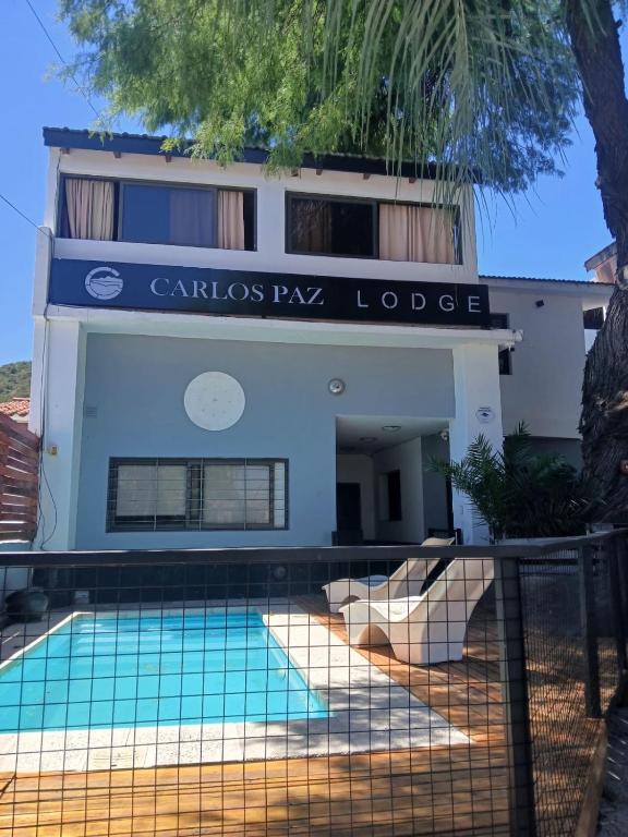 a building with a swimming pool in front of a building at Carlos Paz Hostel Lodge in Villa Carlos Paz