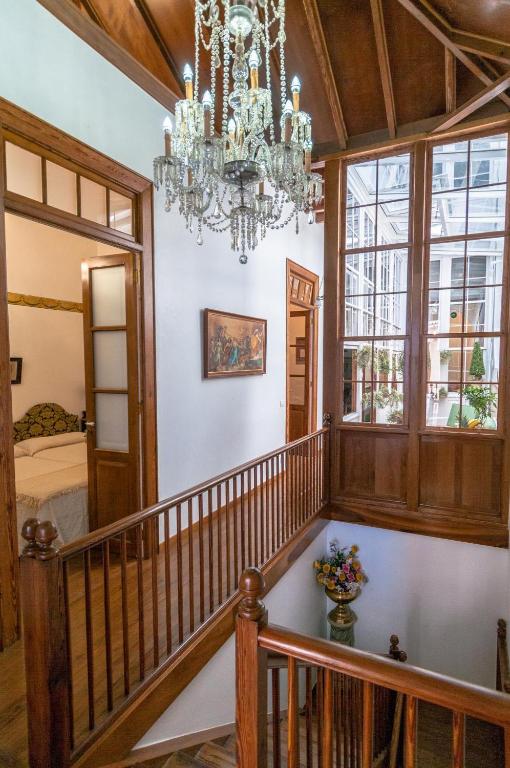 een kroonluchter hangt aan het houten plafond van een kamer met een trap bij Casa Celestino in Santa Cruz de la Palma