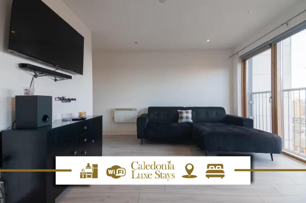 a living room with a black couch and a flat screen tv at Argyle Place in Glasgow