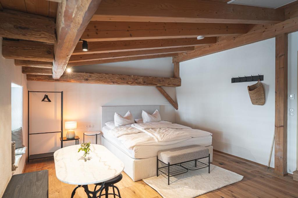 a bedroom with a white bed and a table at tobel 1853 apartments in Leutkirch im Allgäu