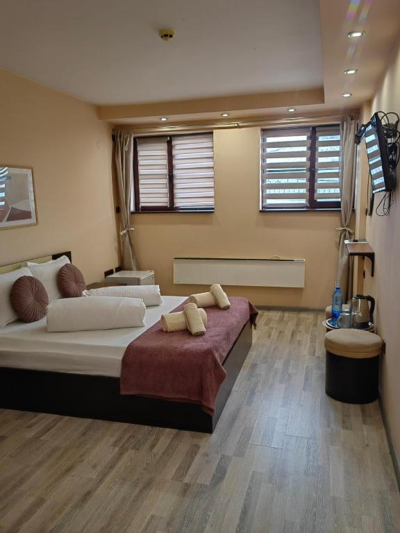 a large bedroom with a large bed and two windows at Hostel By the Hill in Veliko Tŭrnovo