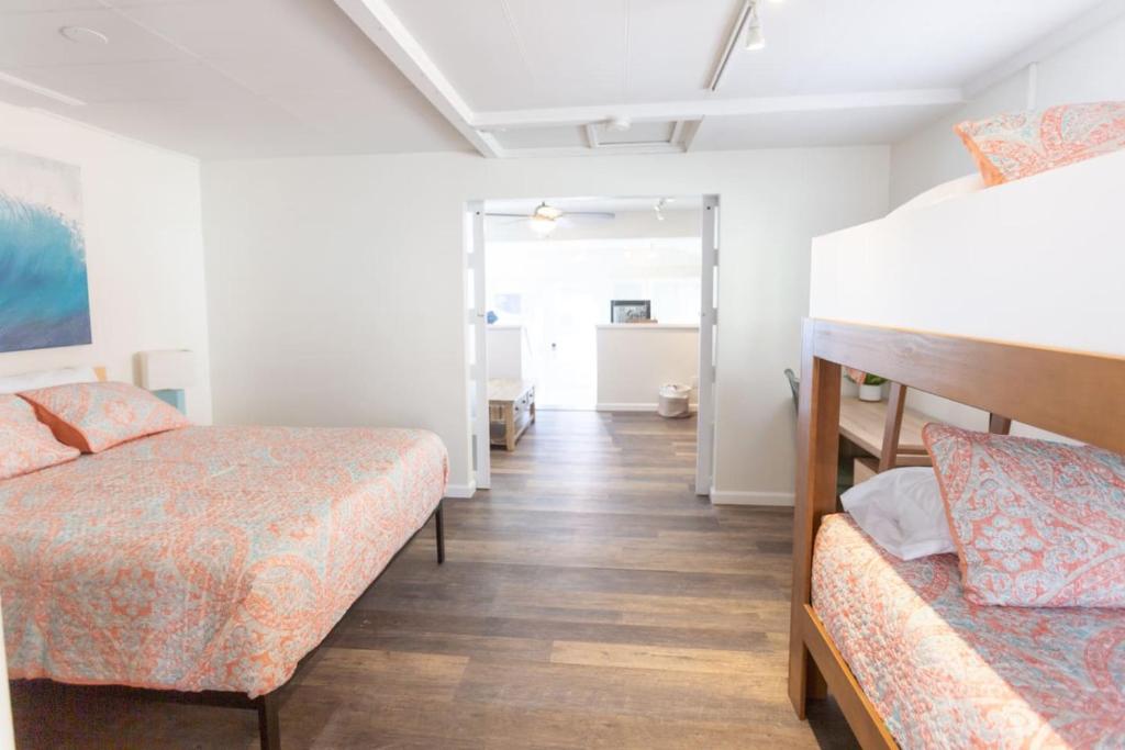 a bedroom with two bunk beds and a hallway at Beachside Bungalow steps from sand in San Diego