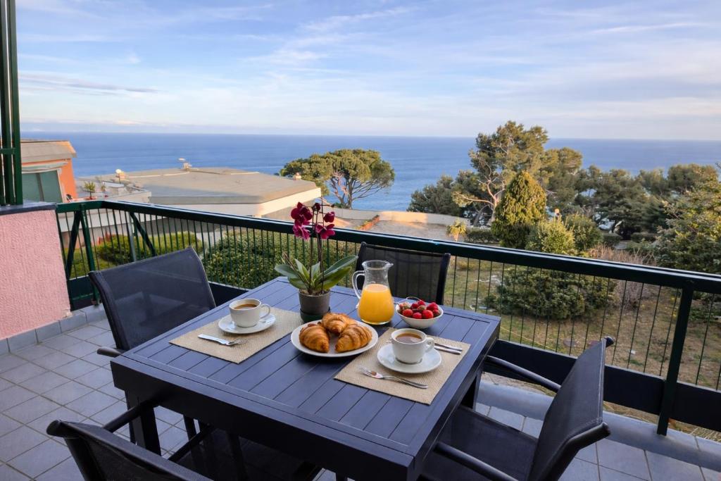 a table with a plate of food on a balcony at Bergeggi Sea View Apartment - Torre del Mare in Bergeggi