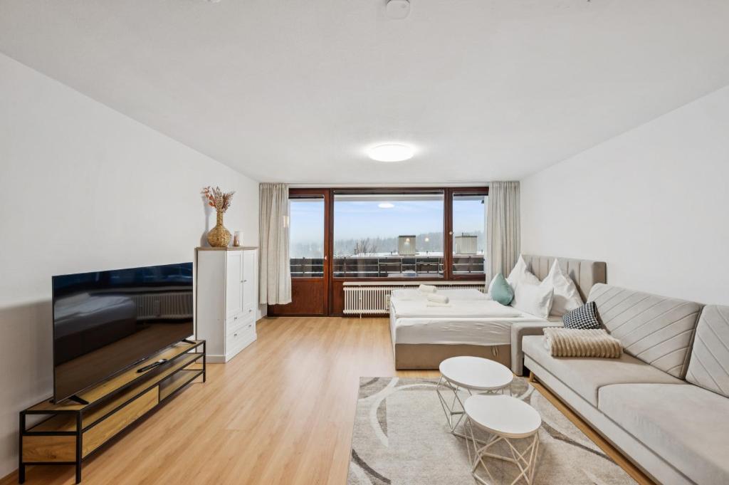 a living room with a couch and a table at Ramoni Apartments - NaturTraum Kniebis in Freudenstadt