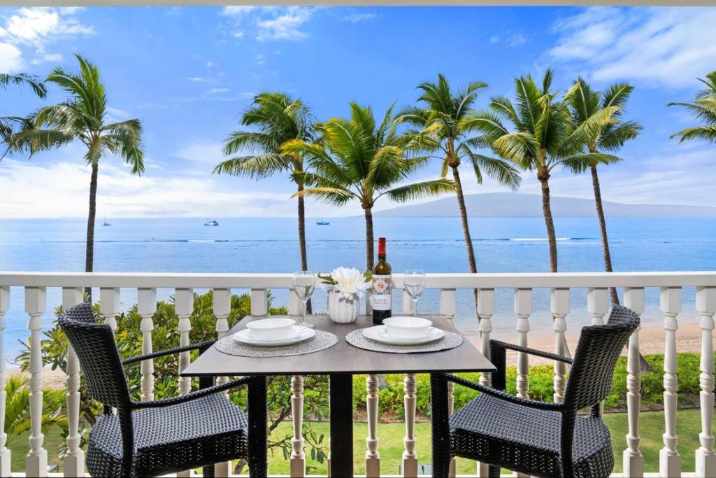 a table on a balcony with a view of the ocean at Aloha Oceanfront Retreat 327 in Lahaina