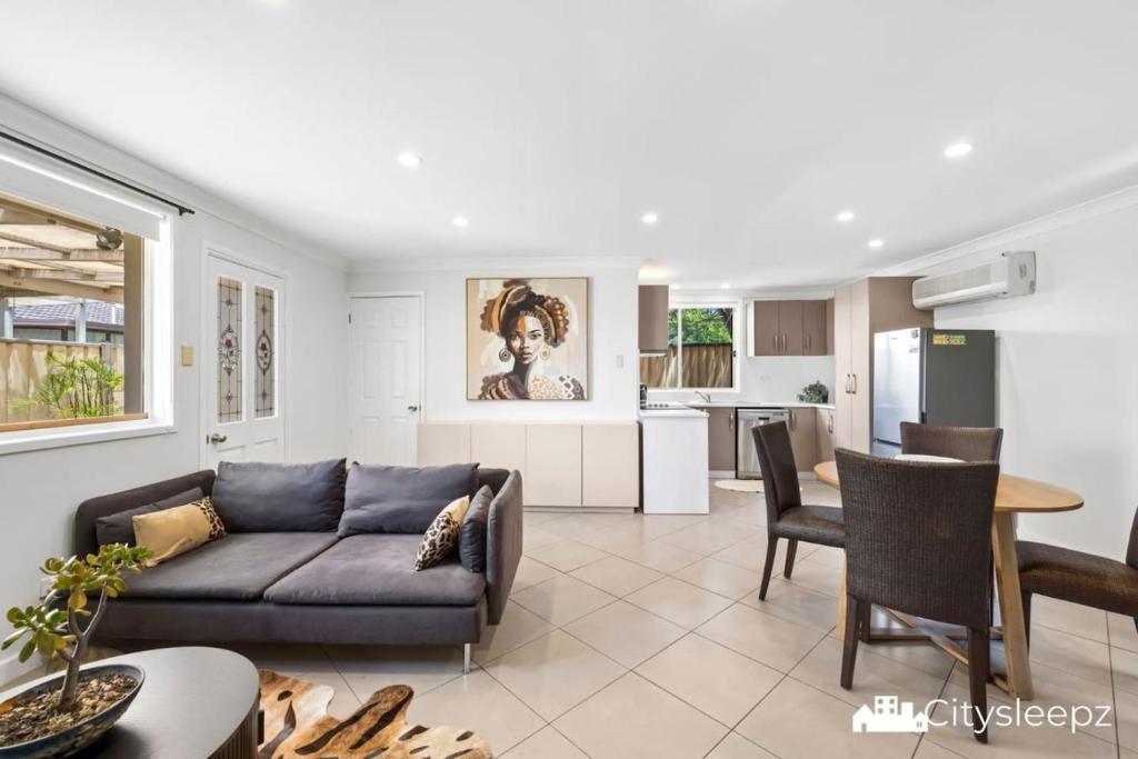 a living room with a couch and a kitchen at Dean Park 2-Bed Unit in Deer Park