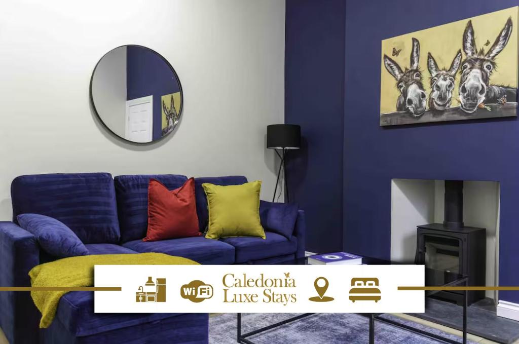 a living room with a blue couch and a mirror at Braelochan Stay in Balloch