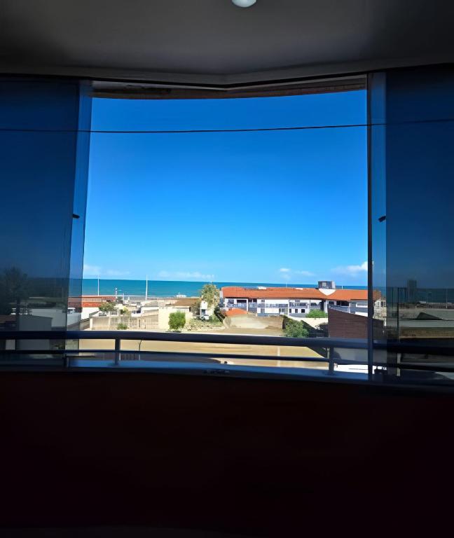 a window in a building with a view of a parking lot at Apartamento interino com vista mar in Natal