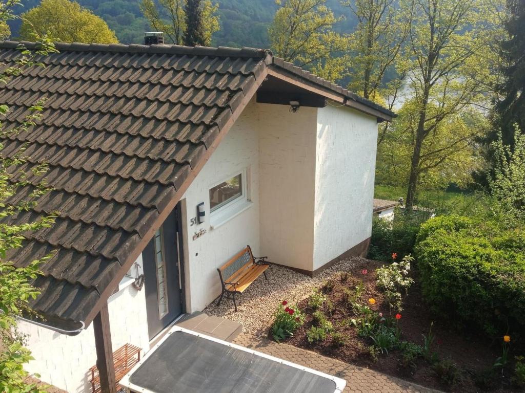 a small white house with a bench in front of it at Holiday Home Stausee by Interhome in Biersdorf am See